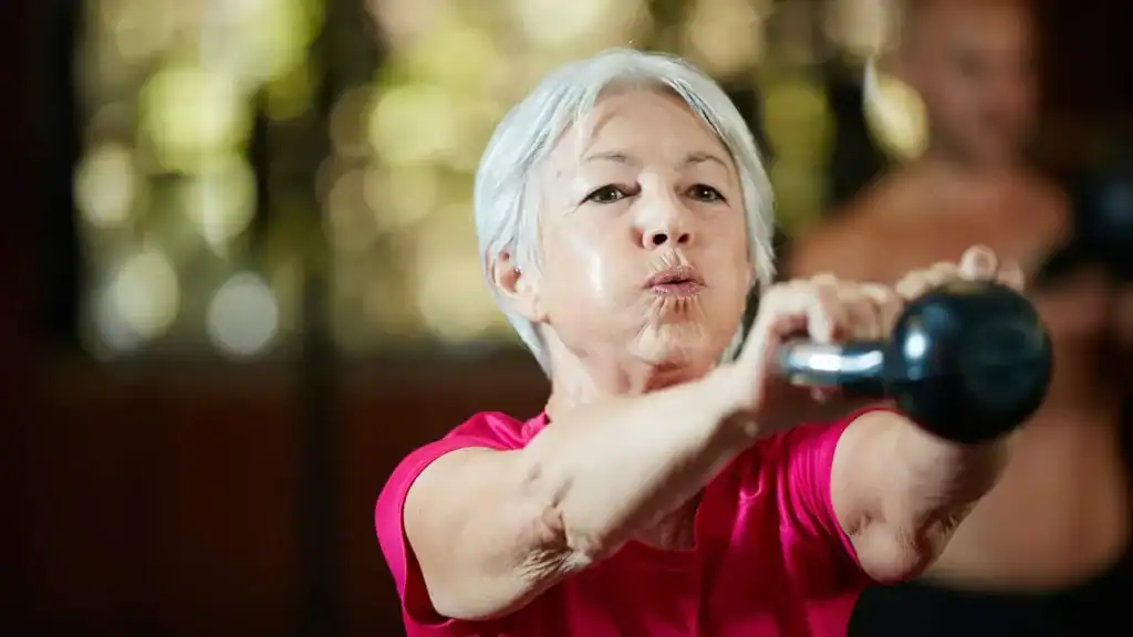 Toning Arms After 60: Empowering Womens Fitness Through Effective Weight Training 1 Older woman doing weight training Newport to help her strength and longevity