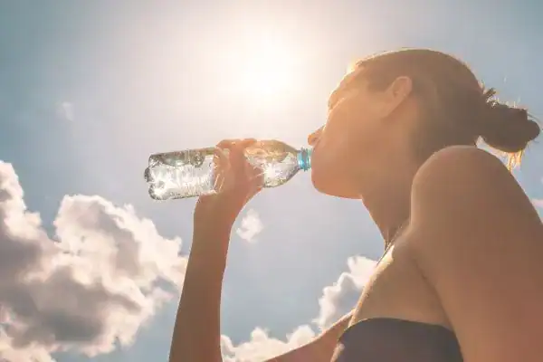 Hydration: The Secret Ingredient for a Toned Stomach and Enhanced Fitness 3 Image of woman drinking water to hydrate Newport after run.